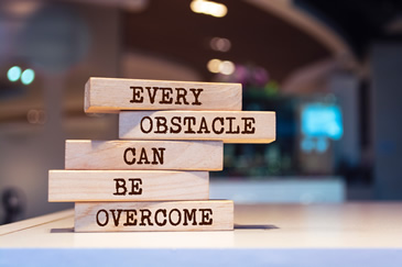 Inspirational wooden blocks about overcoming real estate exam obstacles with NightBeforeTheExam.com 